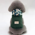 Dog wearing a TAILTRAIL premium winter coat with a stylish hood and camo pattern, ideal for cold weather.